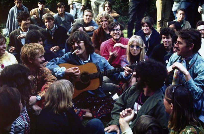 The carefree and free-spirited nature of the counterculture can be felt here, as a group of youth enjoying themselves while surrounding a guitarist can be seen. The edging influence of floral prints and bright colors on streetwear fashion can be seen.